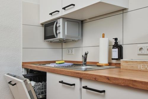 a kitchen with a sink and a microwave at RG Living - Pro Comfort in Herford