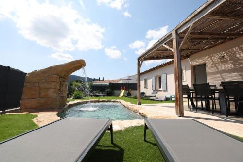 une arrière-cour avec une piscine et un mur en pierre dans l'établissement Superbe Villa climatisée, piscine, jardin, parking, au Plan-de-la-Tour