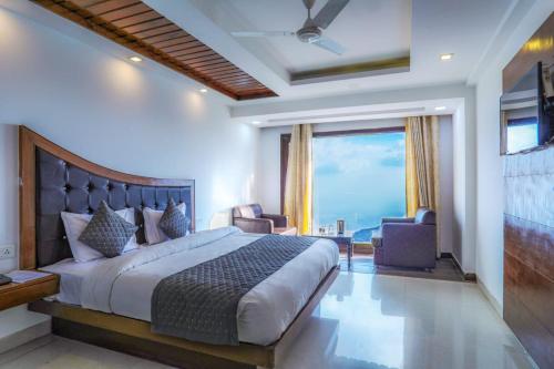 a bedroom with a bed and a large window at Hotel The Grand Valley Tirupati in Mussoorie