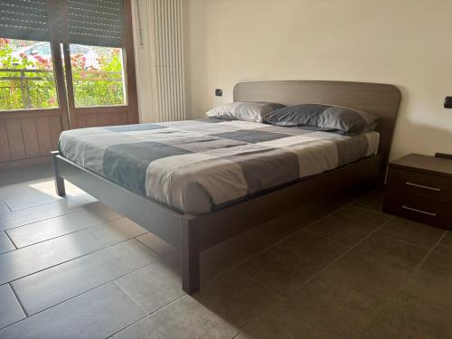 a large bed in a bedroom with a window at La Gare Apartments - Zerbion in Châtillon
