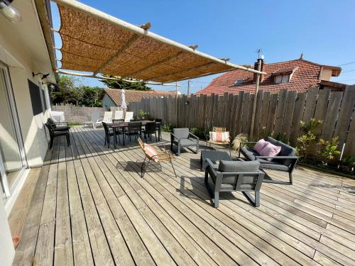un patio avec mobilier et une terrasse en bois dans l'établissement Villa Océane, à Mimizan-Plage