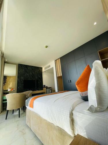 a bedroom with a large bed with an orange pillow at Diamond Palm Hotel & Resort in Al Burj