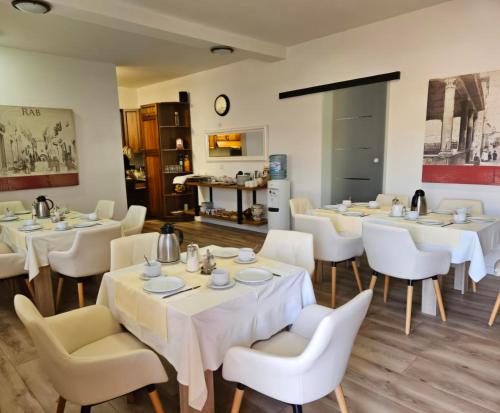 a restaurant with white tables and white chairs at Del Mar Rab in Kampor