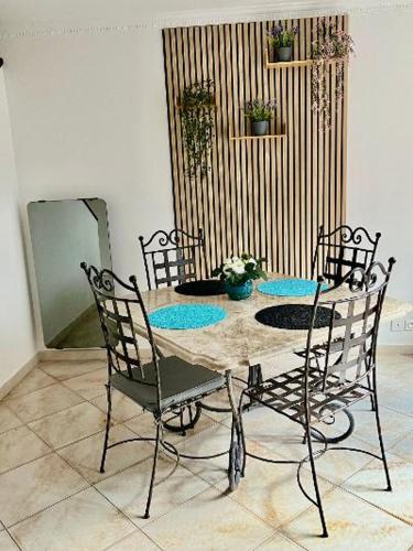 - une table à manger avec 4 chaises, une table et un miroir dans l'établissement Maison PORT FREJUS, à Fréjus