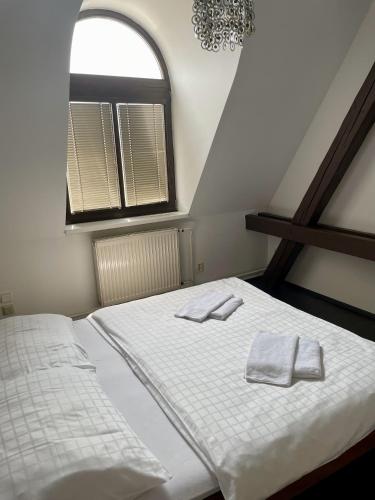 a bedroom with a bed with two towels on it at Hotel Růžek in Hranice