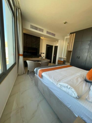 a bedroom with a large bed and a living room at Diamond Palm Hotel & Resort in Al Burj