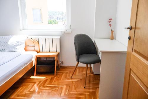 a bedroom with a chair and a desk and a bed at Air Urban in Sarajevo