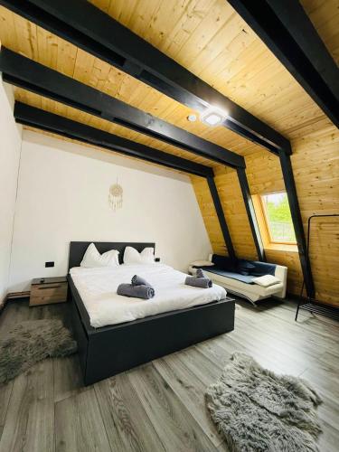 a bedroom with a large bed in a attic at Cabana A-Frame Ariana in Porumbacu de Sus