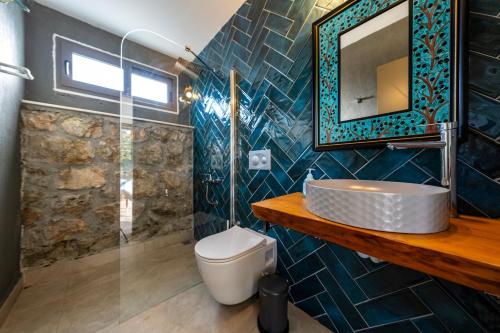 un baño con lavabo y espejo en Jasmine Villa Kaya Köy, en Fethiye