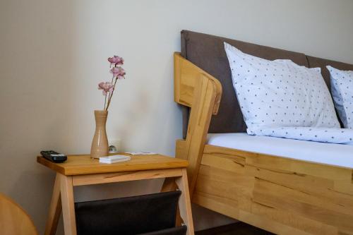 a bedroom with a bed with a table and a vase with flowers at Air Urban in Sarajevo