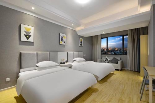 成都Home Inn Paibaiyun Hotel Chengdu Tianyu Road Subway Station Branch的带窗户的酒店房间里有两张床