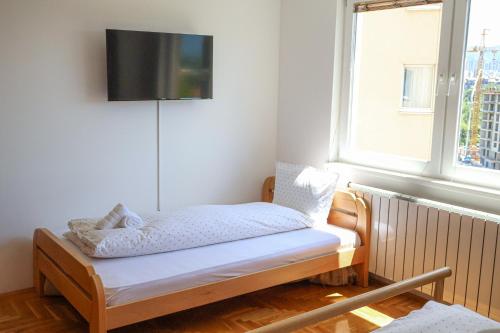 a bed in a room with a tv on a window at Air Urban in Sarajevo