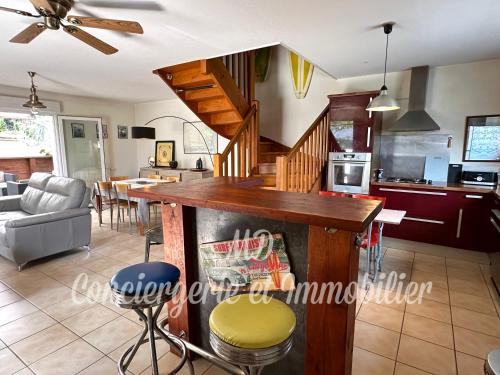 une cuisine et un salon avec une table et des chaises dans l'établissement Maison avec jardin et parking, à Capbreton