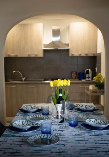 a table with blue and white plates and yellow flowers at Transumare Beach in Vasto