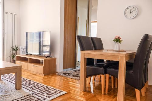 a dining room with a table and chairs and a television at Air Urban in Sarajevo