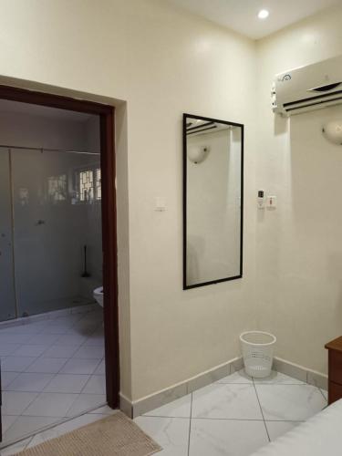 a bathroom with a mirror and a toilet on a wall at BEACH FRONT 3 Bedroom Bungalow in Mombasa