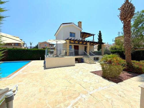 a house with a patio and a swimming pool at Villa Anastasia Sandy Beach Villas - Heated Private Overflow Pool - Hot Tub - Games Room - Private Beach Area in Polis Chrysochous