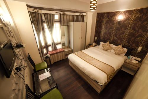 a bedroom with a bed and a large window at Bon The Rink Heritage in Darjeeling
