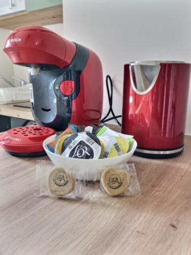 un mélangeur rouge assis sur une table à côté d'un bol dans l'établissement Le Cocon B - private parking - quiet, à Bourg-en-Bresse