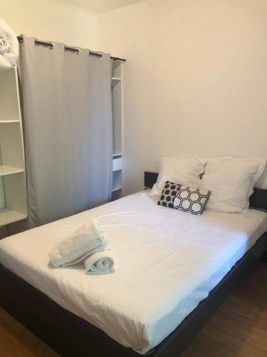 un lit avec des draps blancs et des oreillers dans une chambre dans l'établissement Le Cocon B - private parking - quiet, à Bourg-en-Bresse