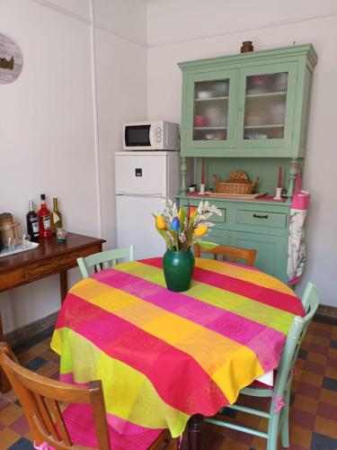 une cuisine avec une table avec un vase de fleurs dessus dans l'établissement Porquerolles - Appartement T2, à Porquerolles