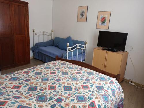 a bedroom with a bed and a couch at Porquerolles - Appartement T2 in Porquerolles