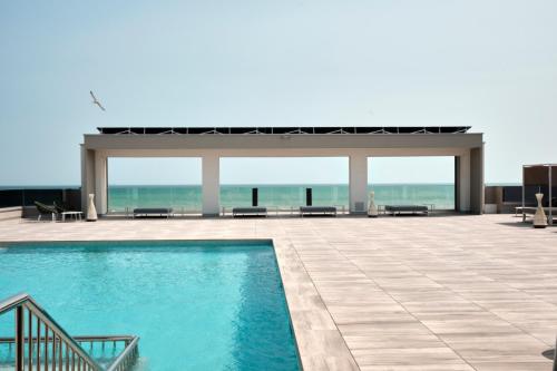 een zwembad met een prieel en de oceaan bij Residence Diana in Bibione