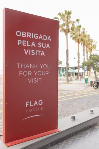 a sign for a hotel on the side of a street at Flag Hotel Madeira - Ribeira Brava in Ribeira Brava