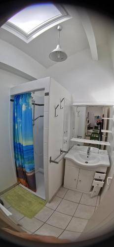 une salle de bain blanche avec un lavabo et un miroir dans l'établissement Rêve et Soleil, à Adissan