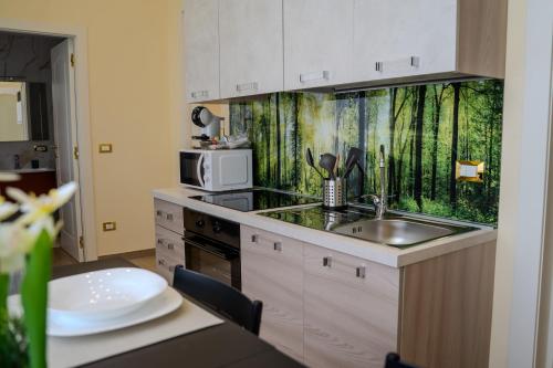a kitchen with a sink and a microwave at Luxury Acclavio Apartments in Taranto