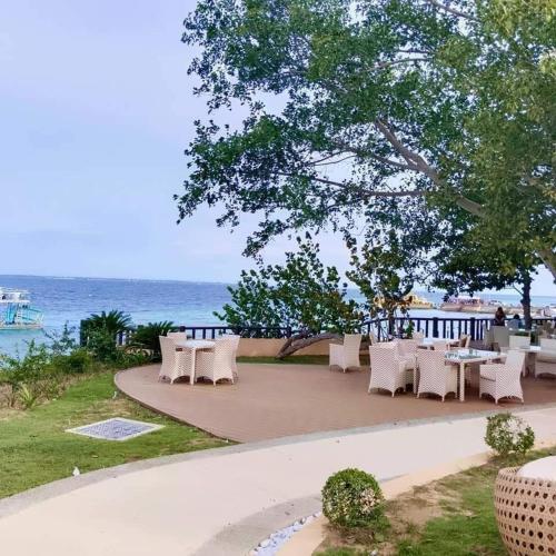 マクタンにあるOne Pacific Residence with Ocean Viewの海辺のテーブルと椅子