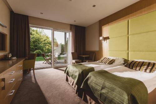 a hotel room with two beds and a balcony at HOTEL KOZI GRÓD Pokoje i Domki na Kaszubach in Pomlewo