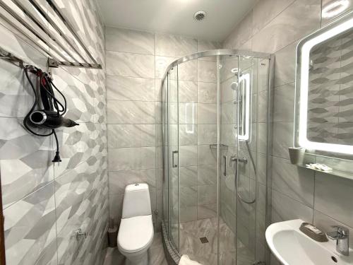 a bathroom with a shower and a toilet and a sink at Villa Santorini in Zatoka