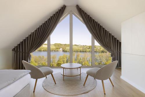 a room with a large window with a table and chairs at Raduńskie Zacisze in Chmielno