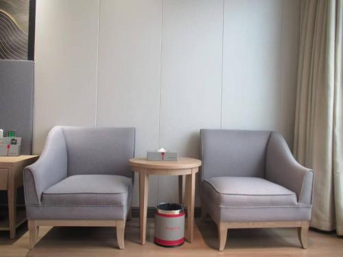 two chairs and a table in a room at Ramada by Wyndham Zhangjiajie Tianmen Mountain in Zhangjiajie