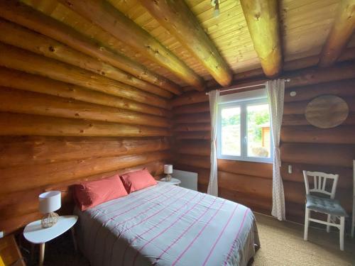 une chambre avec un lit dans une cabane en rondins dans l'établissement Landscape chalet, à Saint-Christophe
