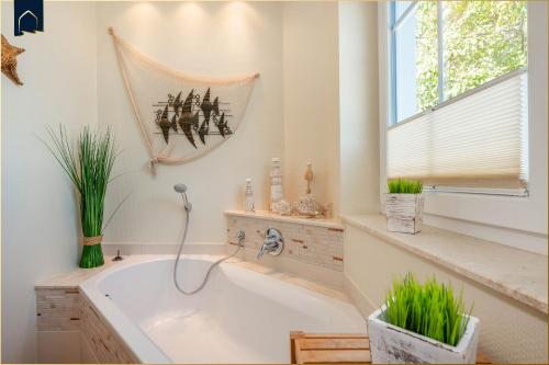 a bath tub in a bathroom with a window at Koserow Hauptstraße 102 Whg 4 in Ostseebad Koserow