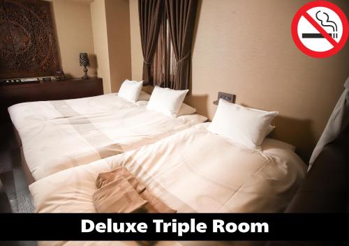 two beds in a hotel room with a no smoking sign at Anda no Mori Osaka Tennoji Tower Near Namba - Family Kids Concept in Osaka