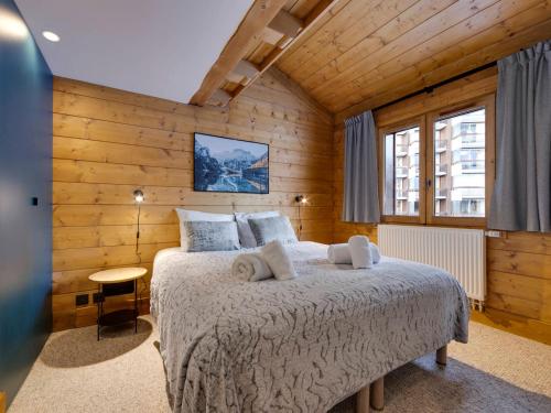 sypialnia z łóżkiem w pokoju z drewnianymi ścianami w obiekcie Duplex confortable au cœur de Tignes Val Claret, 3 chambres, proche centre et navettes - FR-1-641-14 w mieście Tignes