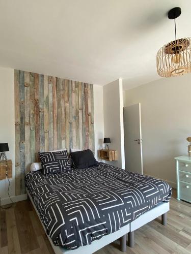 une chambre avec un lit avec une couette noire et blanche dans l'établissement Appartement T2 renové en 2023, à Lannion