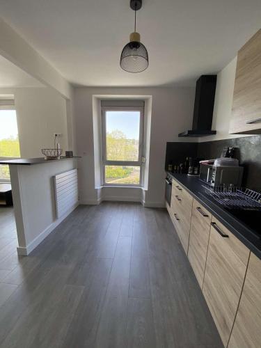 une cuisine avec un comptoir et une grande fenêtre dans l'établissement Appartement T2 renové en 2023, à Lannion