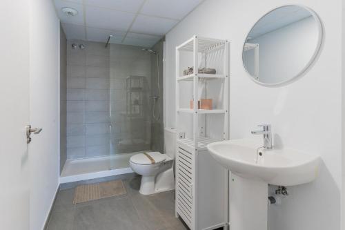 a white bathroom with a toilet and a sink at Canet Seaview Gem: Pool & Beach Proximity in Canet de Berenguer
