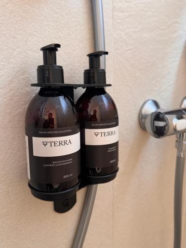 two bottles of wine hanging on a wall at Talè Restaurant & Suite in Piedimonte Etneo