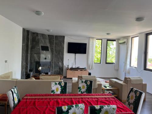 a living room with a table and chairs and a tv at The Byala Escape, Private Villa with Bar & Hot Tub in Byala