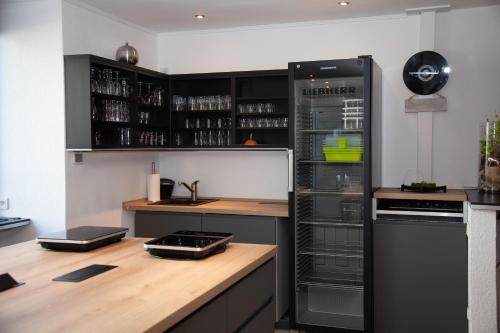 a kitchen with a black refrigerator and a wooden counter at WohnRaum Gäste- & Boardinghaus in Gusterath
