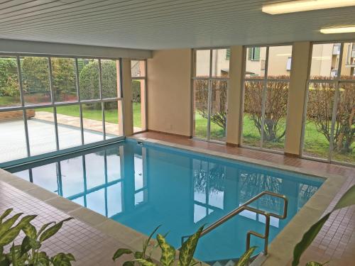 een zwembad in een gebouw met ramen bij Alle Vigne, 3 Stock by HolAp SA in Ascona