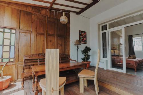 uma sala de jantar com mesa e cadeiras de madeira em Rajabali Villa Batu em Tlekung