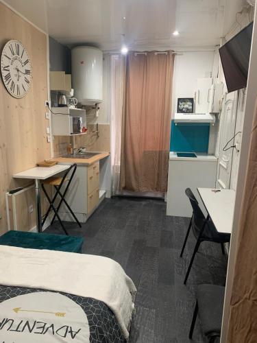 Cette chambre comprend un lit, une table et une cuisine. dans l'établissement Studio en centre-ville, à Clermont-Ferrand