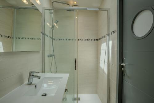 une salle de bain avec une douche, un lavabo et un miroir dans l'établissement Appartement centre ville pour 2 personnes, à Andernos-les-Bains