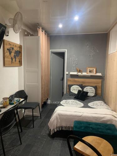 une chambre avec un lit, une table et un bureau dans l'établissement Studio en centre-ville, à Clermont-Ferrand